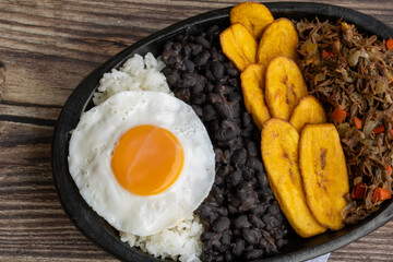 Delicious Venezuelan pabellón criollo with rice, beans, shredded beef, plantain and fried egg. Authentic Latin food photography