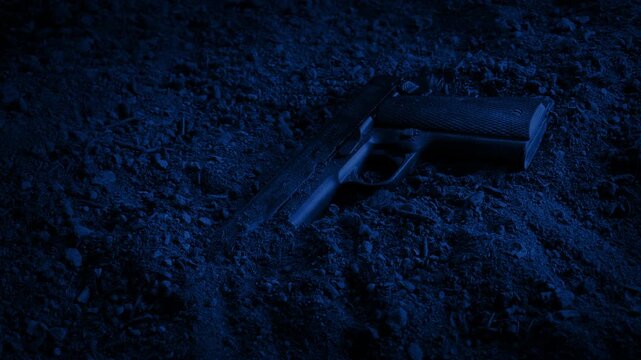 Hand Gun On The Ground At Night
