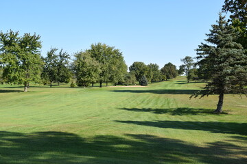 Manicured golf course fairway on a bright and sunny summer afternoon.