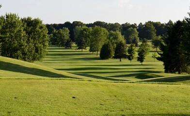 Manicured golf course fairway on a bright and sunny summer afternoon.