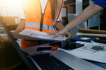Closeup of team of industrial engineers meeting analyze machinery blueprints consult project on table in manufacturing factory. Working in manufacturing plant or production plant.