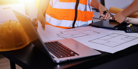 Closeup of team of industrial engineers meeting analyze machinery blueprints consult project on table in manufacturing factory. Working in manufacturing plant or production plant.