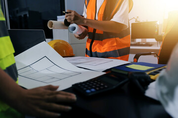 Closeup of team of industrial engineers meeting analyze machinery blueprints consult project on table in manufacturing factory. Working in manufacturing plant or production plant.