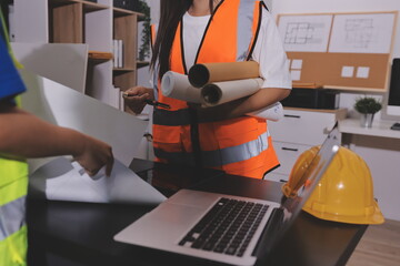 Closeup of team of industrial engineers meeting analyze machinery blueprints consult project on table in manufacturing factory. Working in manufacturing plant or production plant.