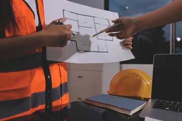 Closeup of team of industrial engineers meeting analyze machinery blueprints consult project on table in manufacturing factory. Working in manufacturing plant or production plant.