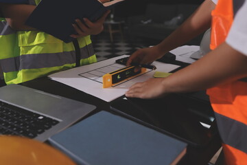 Closeup of team of industrial engineers meeting analyze machinery blueprints consult project on table in manufacturing factory. Working in manufacturing plant or production plant.