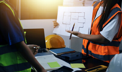 Closeup of team of industrial engineers meeting analyze machinery blueprints consult project on table in manufacturing factory. Working in manufacturing plant or production plant.