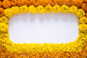 Yellow and orange color marigold flowers and petals rangoli for Diwali festival with white space background.