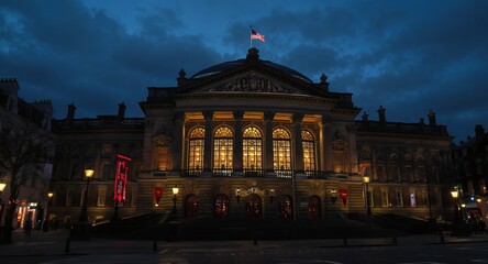 Naklejka premium Nighttime View of Illuminated Grand Building with Flag