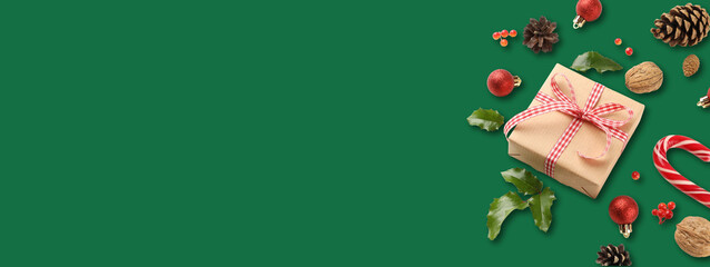 A gift is nestled among Christmas ornaments and greens