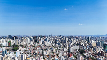 Fototapeta premium Drone view over São Paulo’s dense city center with tall buildings and endless streets forming a massive urban grid, showcasing Brazil’s vibrant economic capital.