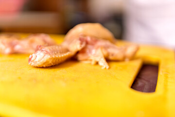 Raw chicken wings preparing on yellow cutting board
