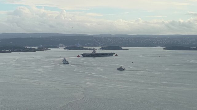 Aircraft Carrier USS Gerald R. Ford In The Fjord With Nearby Islands In Oslo, Norway. - aerial shot