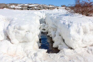 Snow-covered ravine with a stream