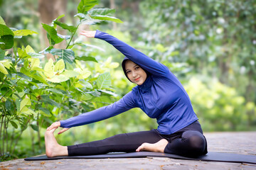 Healthy Asian woman in sportswear do yoga at the park. Moslem woman with sportwear.