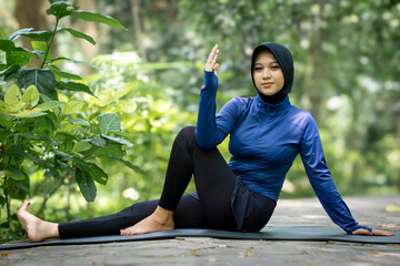 Healthy Asian woman in sportswear do yoga at the park. Moslem woman with sportwear.
