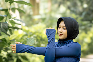 Healthy Asian woman in sportswear do yoga at the park. Moslem woman with sportwear.