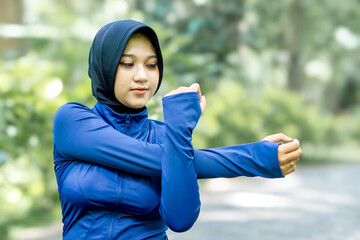 Healthy Asian woman in sportswear do yoga at the park. Moslem woman with sportwear.