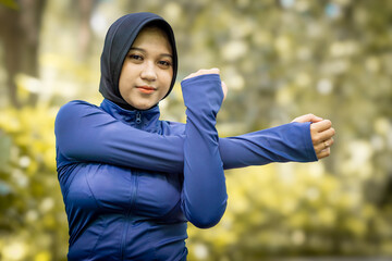 Healthy Asian woman in sportswear do yoga at the park. Moslem woman with sportwear.