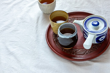 お盆に乗せたお茶の入った湯飲み
