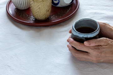 お盆に乗せたお茶の入った湯飲み