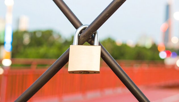 Padlock on a metal fence with city lights in the background