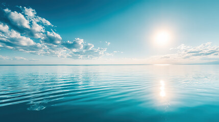 Fototapeta premium Mirror-calm sea under pale-blue sky, where gentle ripples catch the central sun’s glow, evoking vacation serenity and boundless open-air freedom