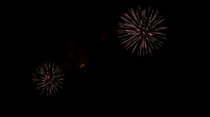 Fototapeta premium A low-contrast, gently lit, moody photographic depiction of a night sky ablaze with vibrant, diffused fireworks, casting subtle illumination and soft shadows