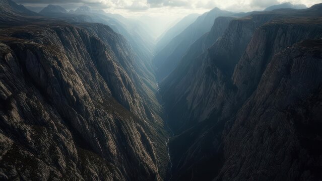 Majestic panoramic view of a deep, dramatic mountain gorge with a winding river below, under a dramatic, cloudy sky.