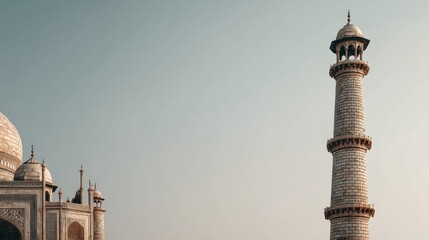 The image shows the intricate minaret and dome of the Taj Mahal against a clear sky, highlighting Mughal architecture's elegance in India.