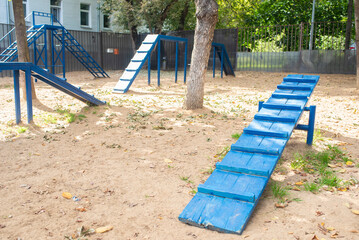 Public city dog ​​park, hurdle ring, artificial obstacles, slide, and training tunnel for dogs.