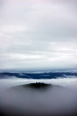 Peaceful tranquil landscape with fog over the mountains