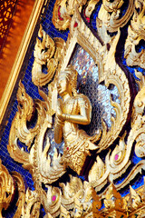 Golden Thai temple art featuring an ornate golden dragon sculpture on a decorated door