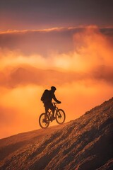 Silhouette of mountain biker on hill at sunset.