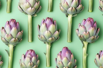 Fototapeta premium Artichoke vegetables from a top view on soft green background of pastel