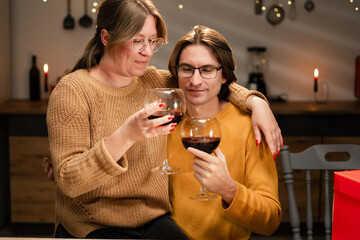 Lovers woman and man clinking wine glasses. romantic dinner with festive lights, celebration Valentine's day or anniversary