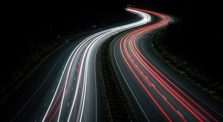 A nighttime highway curves with long light trails of vehicle headlights illuminating the asphalt, creating a dynamic and dramatic scene.
