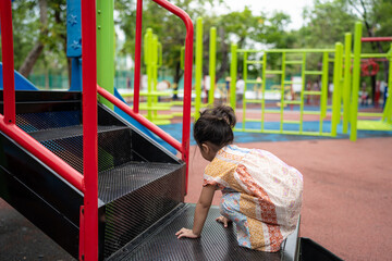 Adorable little girl enjoy climb playground city park