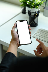 Businessman using smartphone at office desk, blank screen ready for digital content