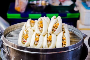 Steamed Bao Buns: A tempting display of freshly steamed bao buns, their fluffy exterior embracing...