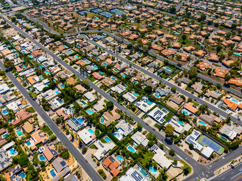 Top down aerial view of luxury homes with swimming pools in Palm Springs, California, showing geometric street layout and suburban symmetry