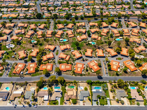Top down aerial view of luxury homes with swimming pools in Palm Springs, California, showing geometric street layout and suburban symmetry