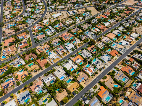 Top down aerial view of luxury homes with swimming pools in Palm Springs, California, showing geometric street layout and suburban symmetry