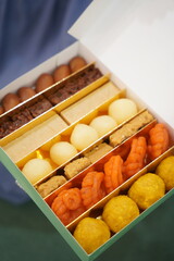 Indian sweets, mithai milk Peda and Halwa or Halva, woman holding Diwali sweets in hand flavored variety assorted dessert Deepavali, Pongal, Dussehra