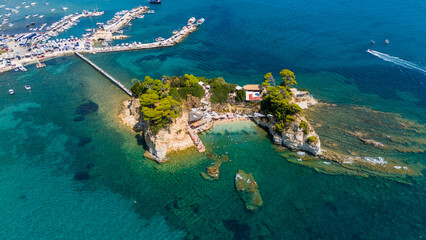 Cameo Island Zakynthos Greece aerial close view of rocky islet with green pine trees wooden bridge...