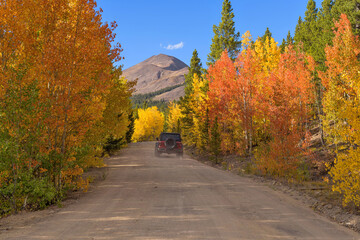 Exploring Autumn Back-country Road - A SUV driving on a scenic back-country road, near the summit of Boreas Pass, on a sunny Autumn evening. Como-Breckenridge, Colorado, USA. © Sean Xu