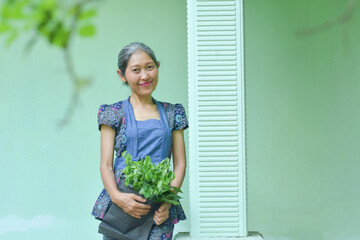 indonesian woman wearing batik on the terrace of her house