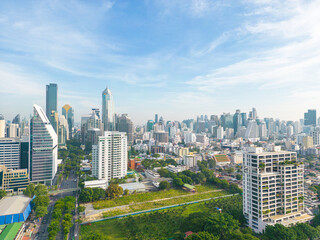 Fototapeta premium Aerial view green tree forest Lumpini public park with modern office building agiant blue sky cloud