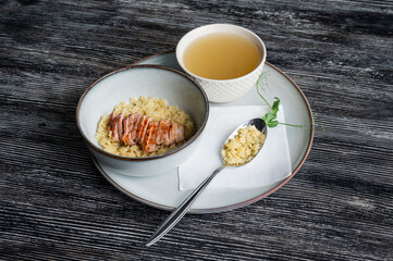Chicken broth with noodles on a wooden table. 
