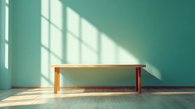A simple, light-filled room features a light-colored wooden bench against a pale teal wall, bathed in the soft shadows of sunlight filtering through a window.